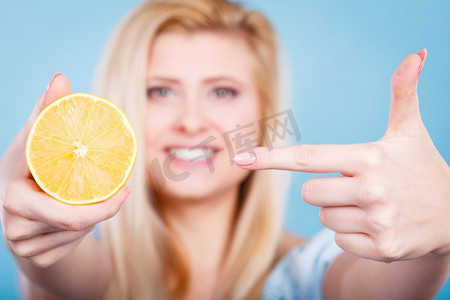 美味水果柠檬摄影照片_健康的饮食，清爽的食物富含维生素。女人拿着甜蜜美味的柑橘水果，柠檬在橙子。妇女拿着水果柠檬或橙子