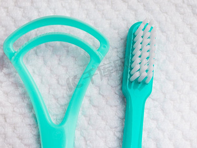 口腔卫生健康概念。特写牙齿工具绿色牙刷和舌头清洁剂在白色毛巾