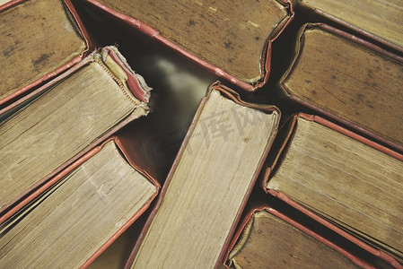 旧书在木地板上俯瞰/精装书堆放在图书馆的书房里，用于商业和教育背景，返校概念