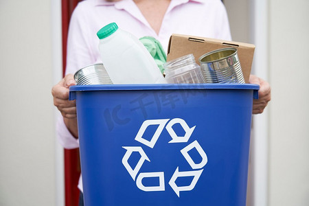 回收再利用摄影照片_关闭妇女举行回收箱的可再利用废物外前门                             