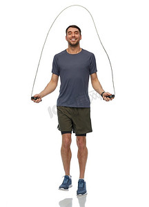 健身，运动和健康的生活方式概念—愉快的微笑的人跳跃与跳绳在白色背景微笑的男子练习跳绳