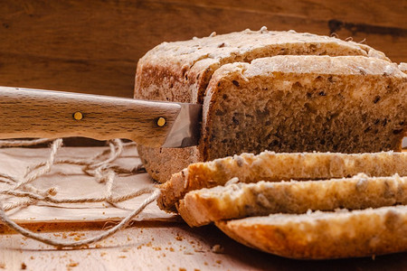 底板文理摄影照片_食物。切碎的全麦面包和切好的木质底板上的刀