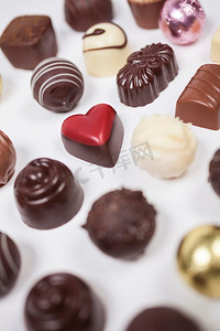 手工制作的巧克力或糖果，包括一个浪漫的心形红色从上面拍摄在白色背景