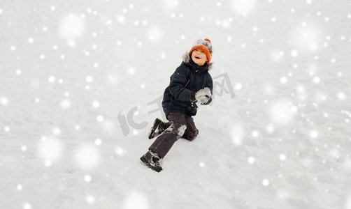 童年，休闲和季节概念—快乐的小男孩玩雪在冬天。快乐的小男孩玩雪在冬天