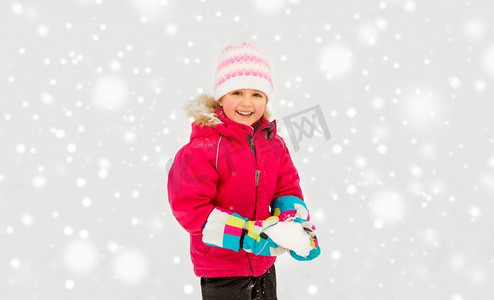 童年，休闲和季节概念—快乐的小女孩玩雪在冬天。快乐的小女孩玩雪在冬天