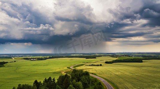 农村宝马摄影照片_暴风雨般的乌云笼罩着田野。麦田上空的雷暴。白俄罗斯，欧洲的农村景象