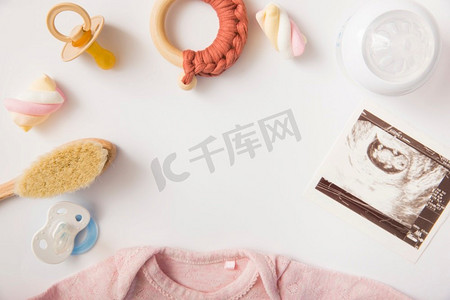 连体框摄影照片_奶嘴棉花糖刷玩具奶瓶超声波图片婴儿连体衣白色背景