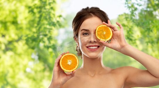 美丽和人概念—微笑的年轻妇女与橙子在绿色自然背景微笑的妇女与橙色在灰色背景