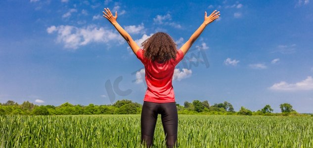 后视图全景网横幅年轻妇女女孩女跑步者慢跑者站立的手臂提高庆祝站在绿色领域与蓝天
