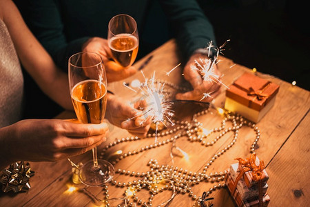 幸福的情侣手持汽水和香槟酒杯参加新年晚会