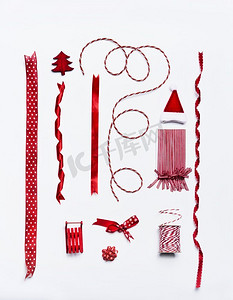 红色圣诞节缎带和蝴蝶结和装饰装饰和礼品包装和包装在白色背景，顶视图，平铺设