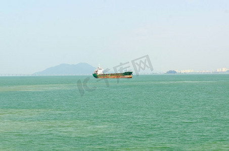 一艘货船驶过槟城大桥的风景图。