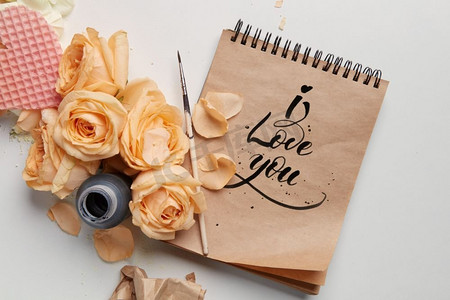 白色玫瑰，笔记本，笔和心的晶圆在一个白色背景与复制空间玫瑰和心与笔记本