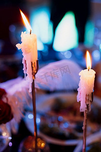 用燃烧的蜡烛装饰桌子，用黑色、红色和白色色调装饰