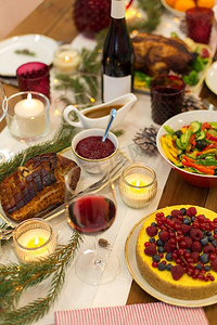 圣诞晚餐摄影照片_圣诞晚餐和饮食概念—食物和饮料在家里的桌子上。在家里的圣诞餐桌上的食物和饮料