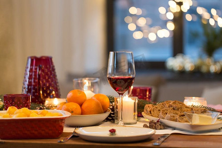 圣诞晚餐和饮食概念-家中餐桌上有一杯红酒和食物。圣诞餐桌上的一杯红酒和食物