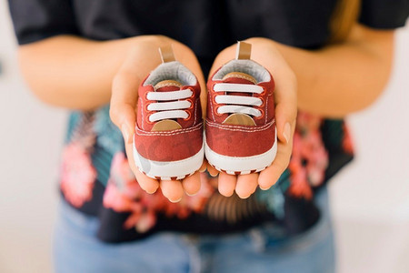 新生儿概念与妇女与小鞋子手