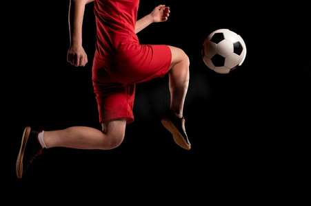 黑色膝盖摄影照片_女子用膝盖踢球的近距离