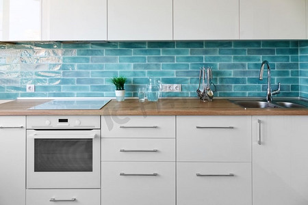 白色厨房在现代风格与厨房配件在蓝色瓷砖背景。全新现代厨房内饰