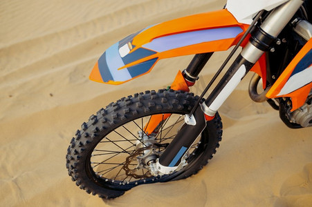 特写镜头的运动摩托车轮胎与软焦点。摩托车越野自行车轮在沙顶视图。具有柔焦的运动摩托车特写轮胎