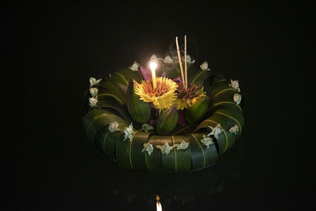 月亮鲜花摄影照片_在泰国，人们购买鲜花和蜡烛来点燃并漂浮在水面上庆祝Loy Krathong节日。