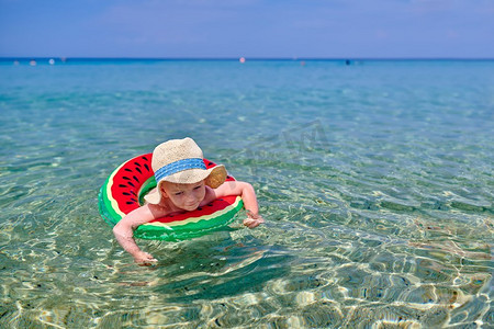 幼儿游泳摄影照片_2岁的蹒跚学步的男孩在海滩游泳与充气环