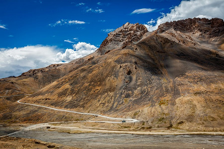 蜿蜒的山路马纳利—列到拉达克与公共汽车在印度喜马拉雅山。印度拉达克喜马拉雅山的马纳利—列路