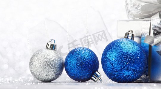 抽象闪光银色背景的装饰性圣诞球和礼物