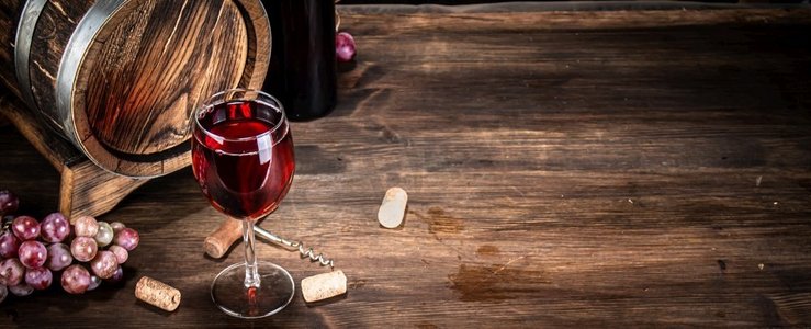 桌上放着一杯红葡萄酒。背景是木制的。。桌上放着一杯红葡萄酒。