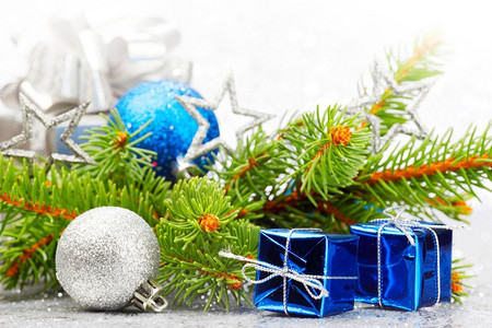 圣诞卡与冷杉树枝和装饰在银闪光背景