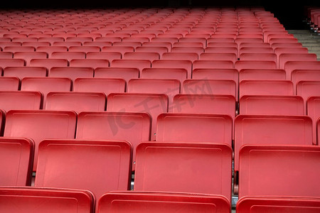 座位席位摄影照片_空的红色座位排在足球场足球