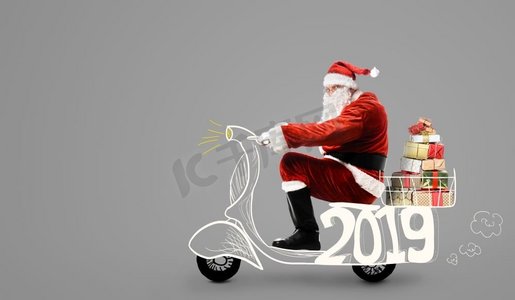 2019新年装饰摄影照片_圣诞老人在摩托车交付圣诞节或新年2019礼物在灰色背景圣诞老人在滑板车