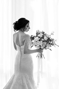 新娘在一个白色的礼服与花束在酒店房间