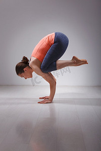 美丽的运动适合瑜伽女练习瑜伽asana Bakasana—起重机姿势手臂平衡在工作室。健身瑜伽女子练习瑜伽体位Bakasana
