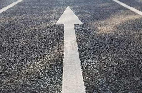 路面标记和交通概念—沥青上的箭头标记特写。沥青路面箭头标记特写