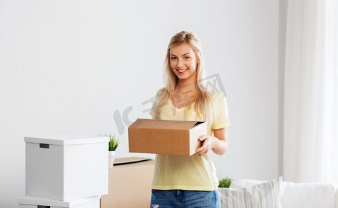 搬家，人和房地产的概念--幸福的女人在新家搬箱子。搬着箱子搬到新家的快乐女人