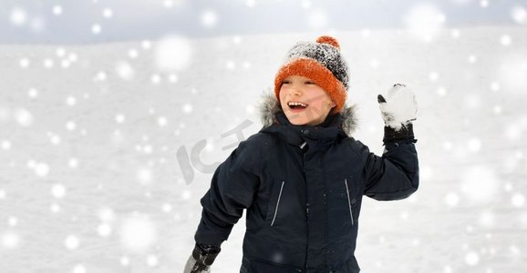 童年，休闲和季节概念—快乐的小男孩扔雪球在冬天。快乐的男孩玩和扔雪球在冬天