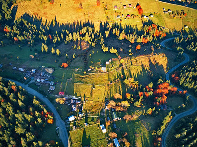 蜿蜒曲折的道路穿过森林和村庄。乌克兰喀尔巴西亚山脉中的高山山口。无人驾驶飞机拍摄的秋季俯瞰。