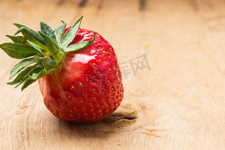 健康的营养饮食。红色新鲜单草莓水果在木桌子板