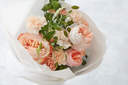 新娘手持结婚花束，背景为灰色石材。美丽的粉色玫瑰