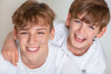 白色背景工作室照片年轻的快乐男孩儿童兄弟微笑在一起