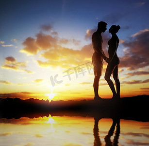 背景是一对相爱的情侣在夕阳下的剪影