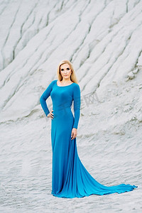 火车与女孩摄影照片_金发女郎在一件蓝色连衣裙与蓝色眼睛在一个花岗岩采石场反对砾石的背景