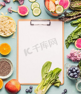 桌子纸张摄影照片_健康的冰沙成分周围剪贴板与空白纸张在轻桌子，顶视图，框架.素食食品清洁饮食