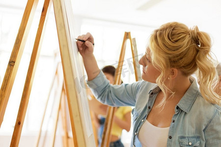 艺术学校，创造力和人的概念—妇女与画架绘画在工作室。妇女与画架绘画在艺术学校工作室