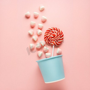 条纹背景摄影照片_创意概念照片糖果篮子在粉红色背景。