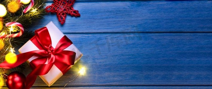 礼物丝带卡摄影照片_圣诞节或新年礼物与节日冷杉树在蓝色桌子在晚上。圣诞或新年礼物