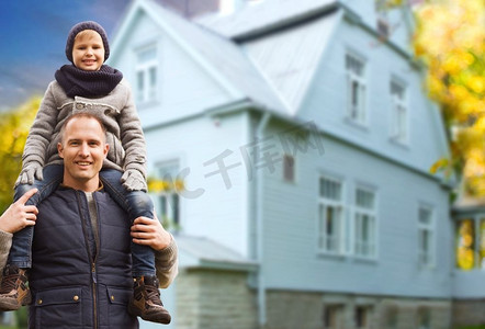 家庭，房地产和父亲的概念—快乐的父亲带着儿子在生活的房子背景。秋天，父亲和儿子在客厅里快乐