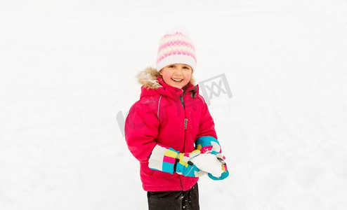童年，休闲，季节概念-快乐的小女孩在冬天玩雪。快乐的小女孩在冬天玩雪
