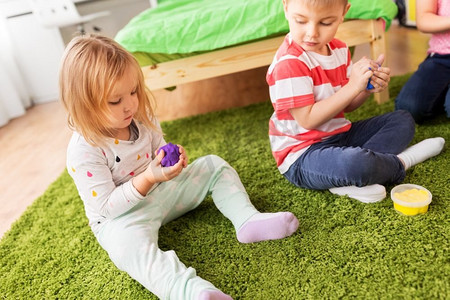 童年、休闲和人的概念—儿童在家中玩模型泥或泥泥。在家里用粘土或泥泥做模特的孩子
